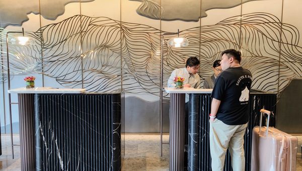 The check-in counter at Momentus Hotel Alexandra is framed by an elegant feature wall that serves as a statement art piece for the lobby.