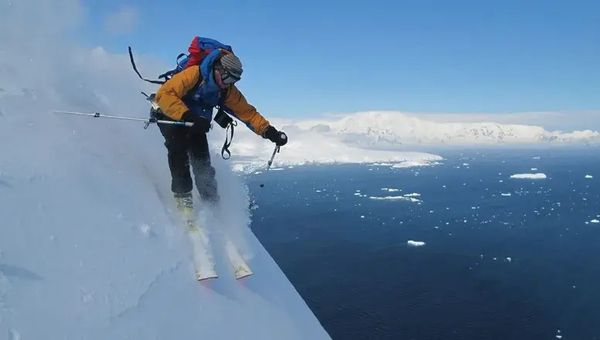 A heli-skier races down a mountain in Antarctica on an extreme adventure tour with Pelorus.