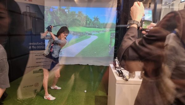 Guests taking the golf simulator for a spin.
