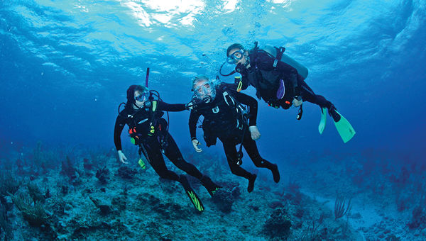 Professional dive guides accompany a disabled diver in Bonaire’s waters. Professional dive guides accompany a disabled diver in Bonaire’s waters.