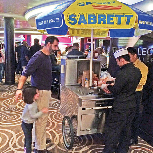 The writer’s husband and daughter order from the Sabrett hot dog cart onboard the Breakaway. The writer’s husband and daughter order from the Sabrett hot dog cart onboard the Breakaway.