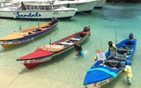 Fishing boats pull up alongside the dock at Sandals Ochi Beach Resort to display the catch of the day and shells from the sea.