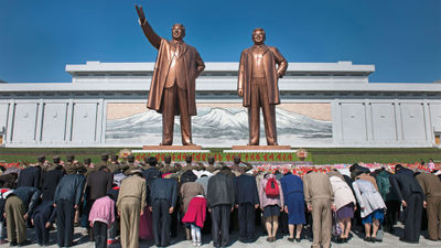 North Koreans bow to the newly unveiled statues of Kim Il Sung and Kim Jong Il in Pyongyang at the Mansudae Grand Monument.