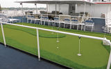 The outside spaces on Deck 5 have a shaded area with banks of cushioned chairs and settees as well as a putting green.