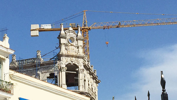 A crane is a symbol of progress in restoration of old buildings in Havana. A crane is a symbol of progress in restoration of old buildings in Havana.