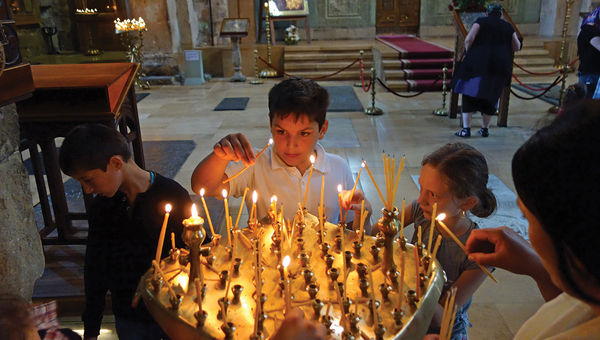 Children light candles in an Orthodox church in Tbilisi, Georgia. Children light candles in an Orthodox church in Tbilisi, Georgia.