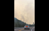 Cars along Highway 2 on the park's border had to travel in a caravan behind a pilot car through areas closest to the fires.