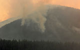 Smoke from fires just outside the southern border of Glacier National Park contributed to a haze that reduced visibility throughout the park. The orange cast to the photo is from the sunset, not flames from the fires.