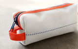 Like all the handmade products from the Oxgut Hose Co., this toiletry kit for men is fashioned from repurposed, genuine fire hose salvaged from U.S. fire departments, which makes it both unique and ecologically sound. Durable and handsome, the kit is made from a white synthetic fire hose liner (with a navy blue stitch); has a clear, rubberized interior that requires no lining; sports blue rubber fire hose details on its exterior bottom; and has a black industrial zipper as well as an orange trim and loop for hanging.