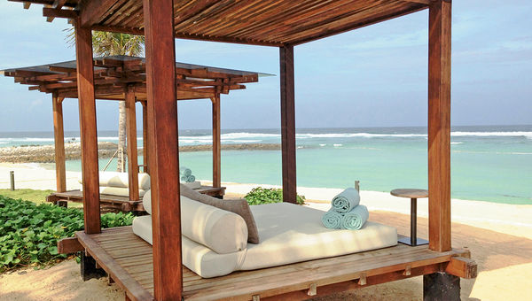 Lounging beds on the beach at the Ritz-Carlton Bali. Guests can enjoy a true island experience at the resort with a Balinese cleansing ceremony, sunrise yoga, meditation sessions or an evening barbecue on the beach with local dancers.
