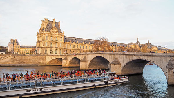 The week after the terror attacks in Paris: Tourists on a boat plying the Seine in front of the Louvre at sunset. The week after the terror attacks in Paris: Tourists on a boat plying the Seine in front of the Louvre at sunset.