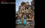 A woman stands in the rubble of an apartment complex in Patan.