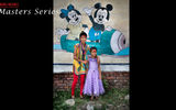 Sisters in front of a wall with Disney characters.