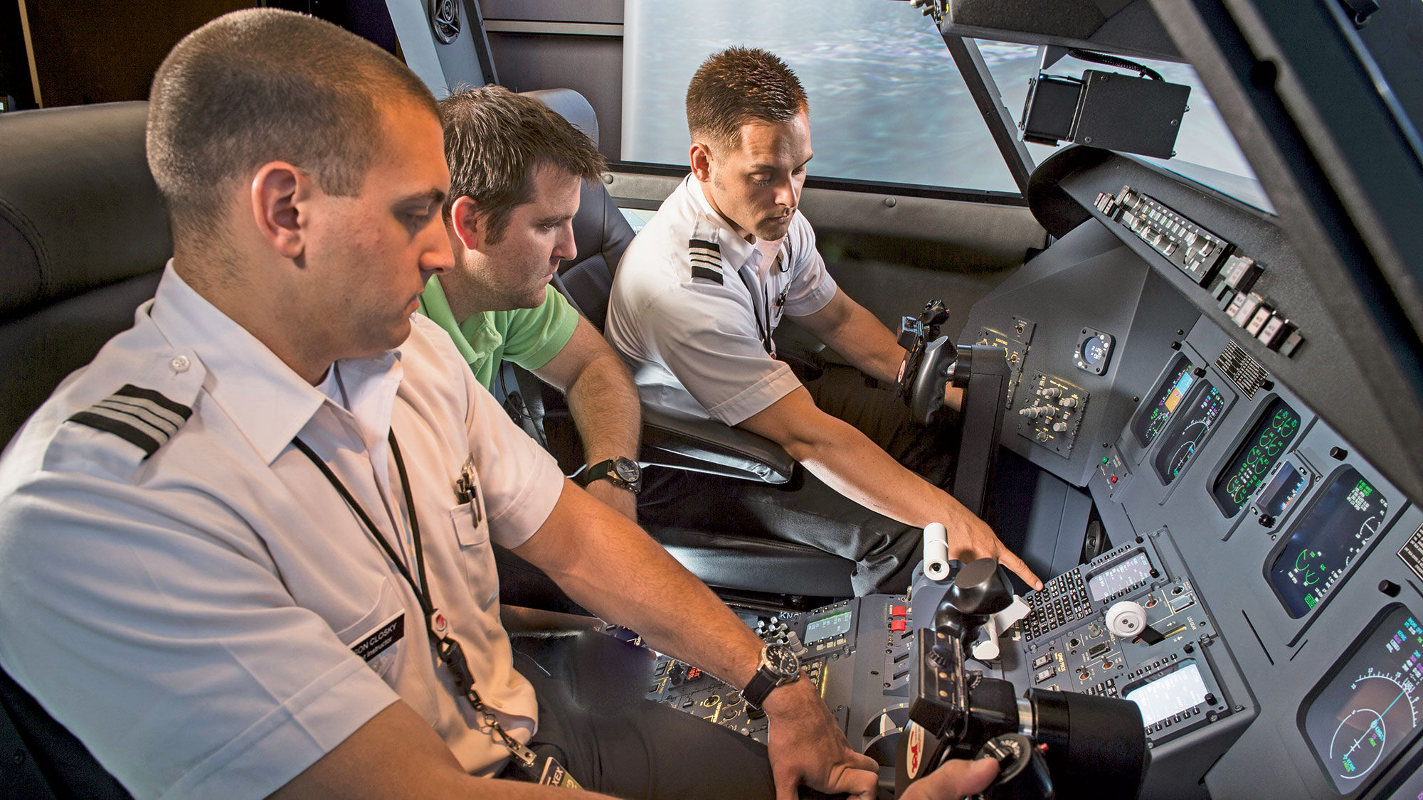 Jacksonville University students Jason Closky, left, and Bill Luce, right, receive a simulator lesson from their professor, Chad Kendall.