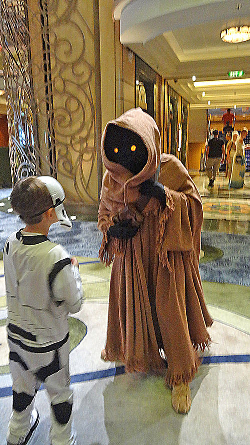 A young passenger dressed as a stormtrooper approaches a Jawa at a Star Wars character meet-and-greet. A young passenger dressed as a stormtrooper approaches a Jawa at a Star Wars character meet-and-greet.