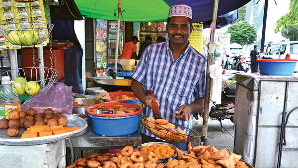 As part of an Intrepid Real Food Adventure tour, travelers visit a market in Malaysia where this man is selling fried street-food snacks. As part of an Intrepid Real Food Adventure tour, travelers visit a market in Malaysia where this man is selling fried street-food snacks.