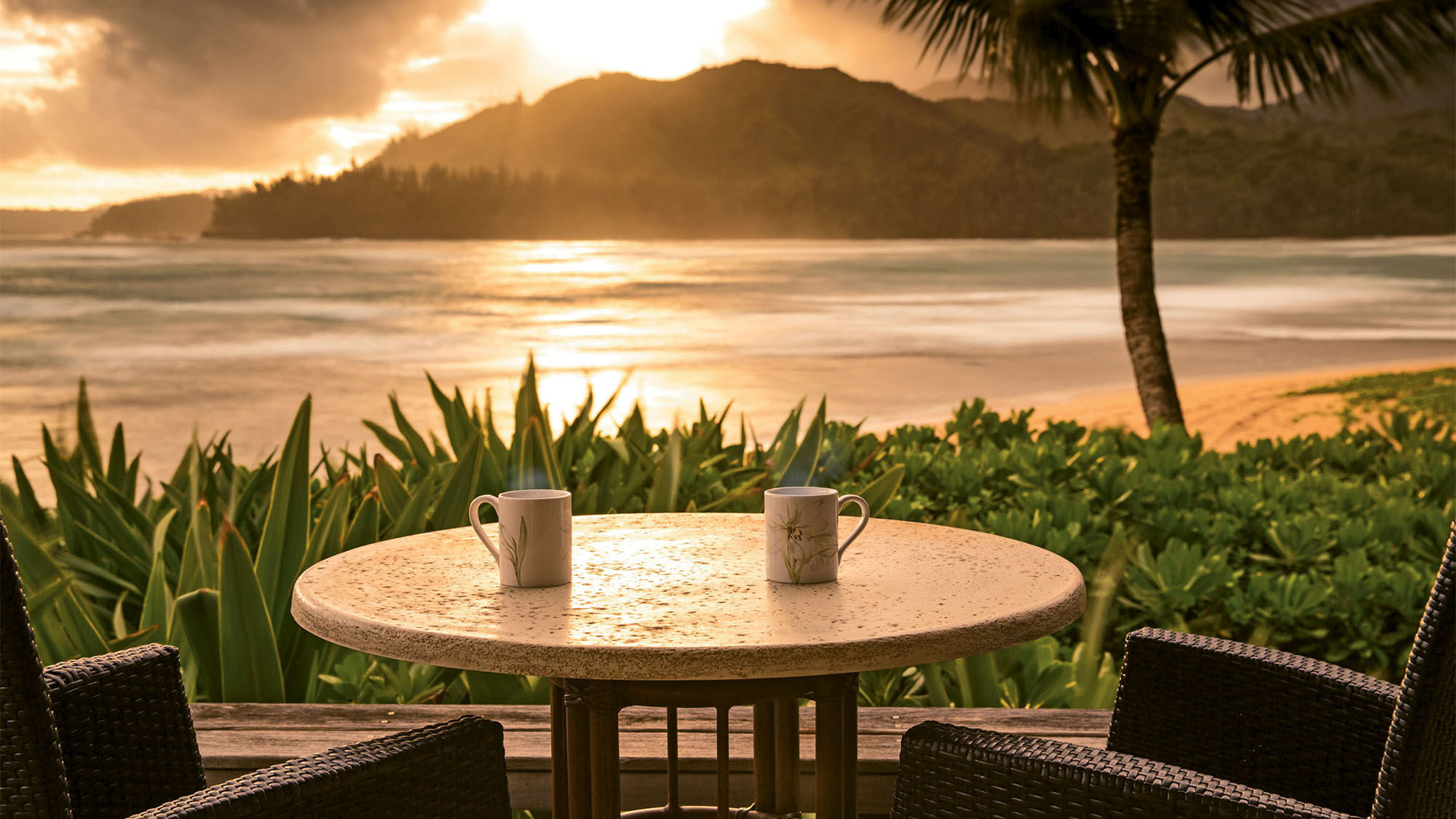 Guests can bring their coffee to watch the sunrise at the Hanalei Colony Resort.