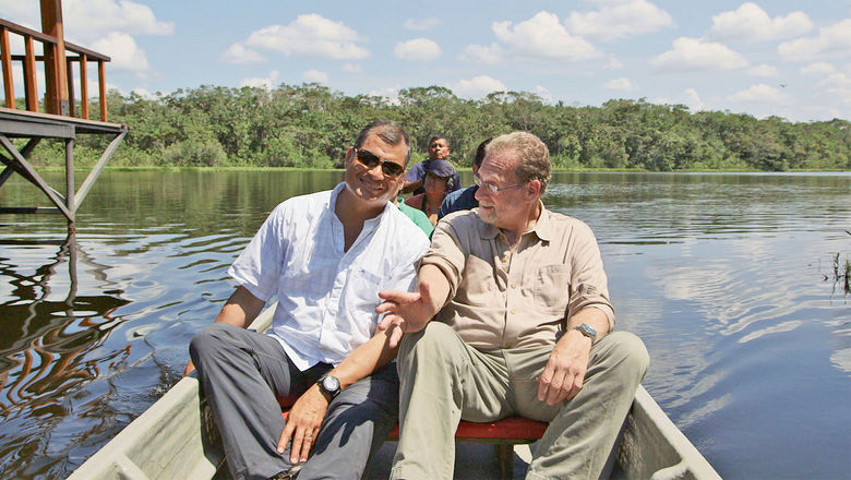 Ecuador president Rafael Correa, left,  and Peter Greenberg ride down the Napo River in the Ecuadorian Amazon rain forest for an episode of “The Royal Tour” on PBS.