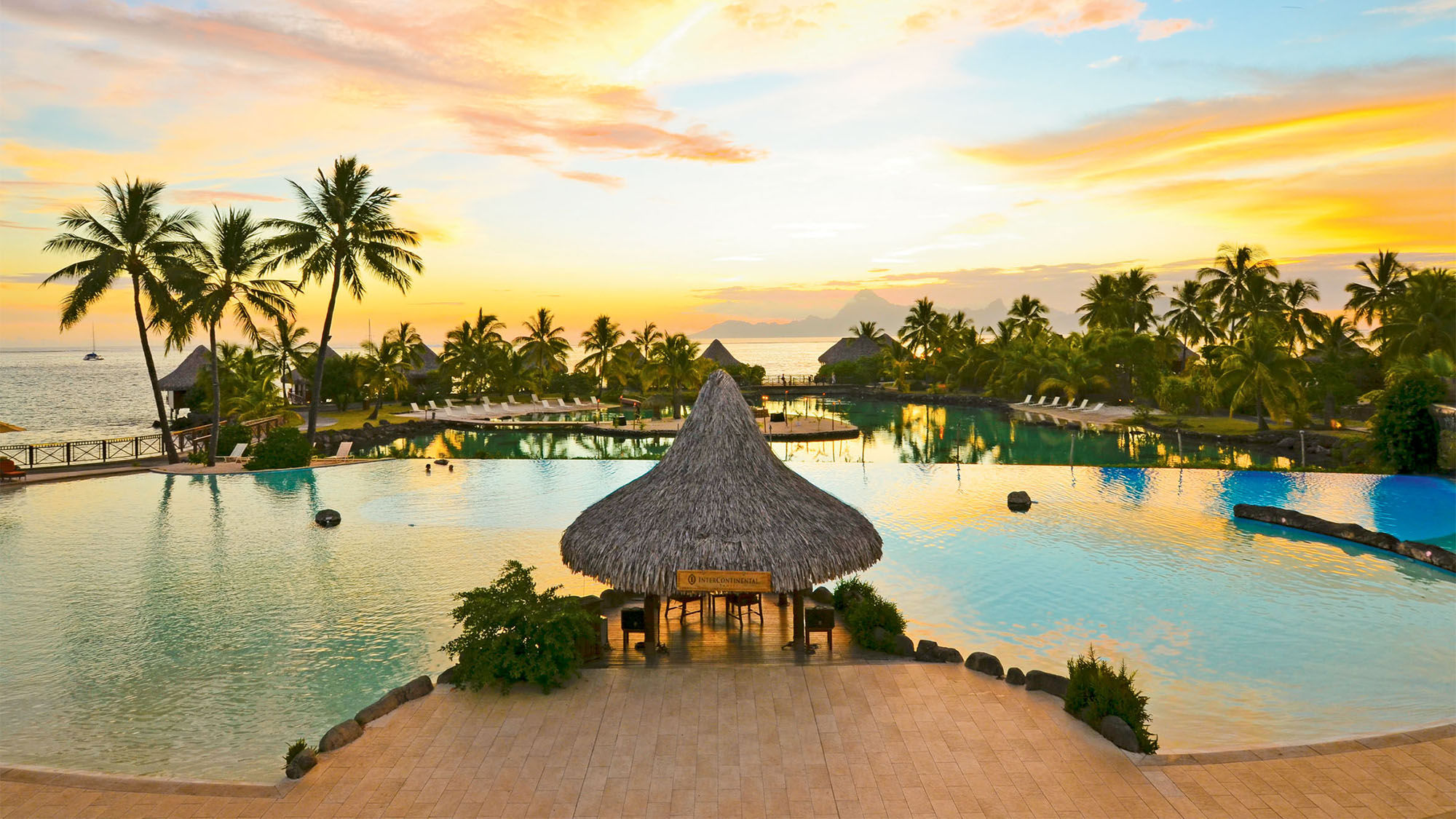 The pool at sunset at the InterContinental Tahiti Resort & Spa. The island of Moorea is in the distance.