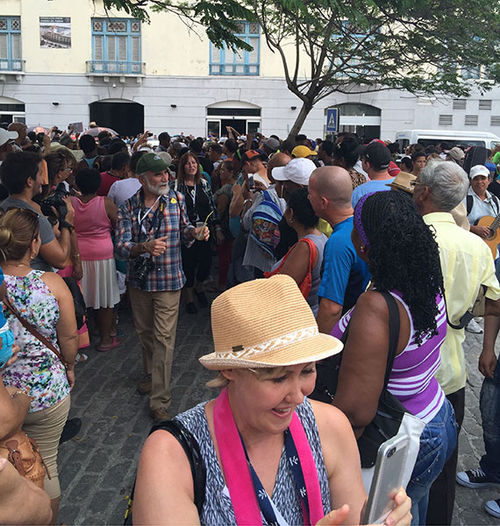 Media crews and locals surround arriving Adonia passengers outside Terminal Sierra Maestra San Francisco.