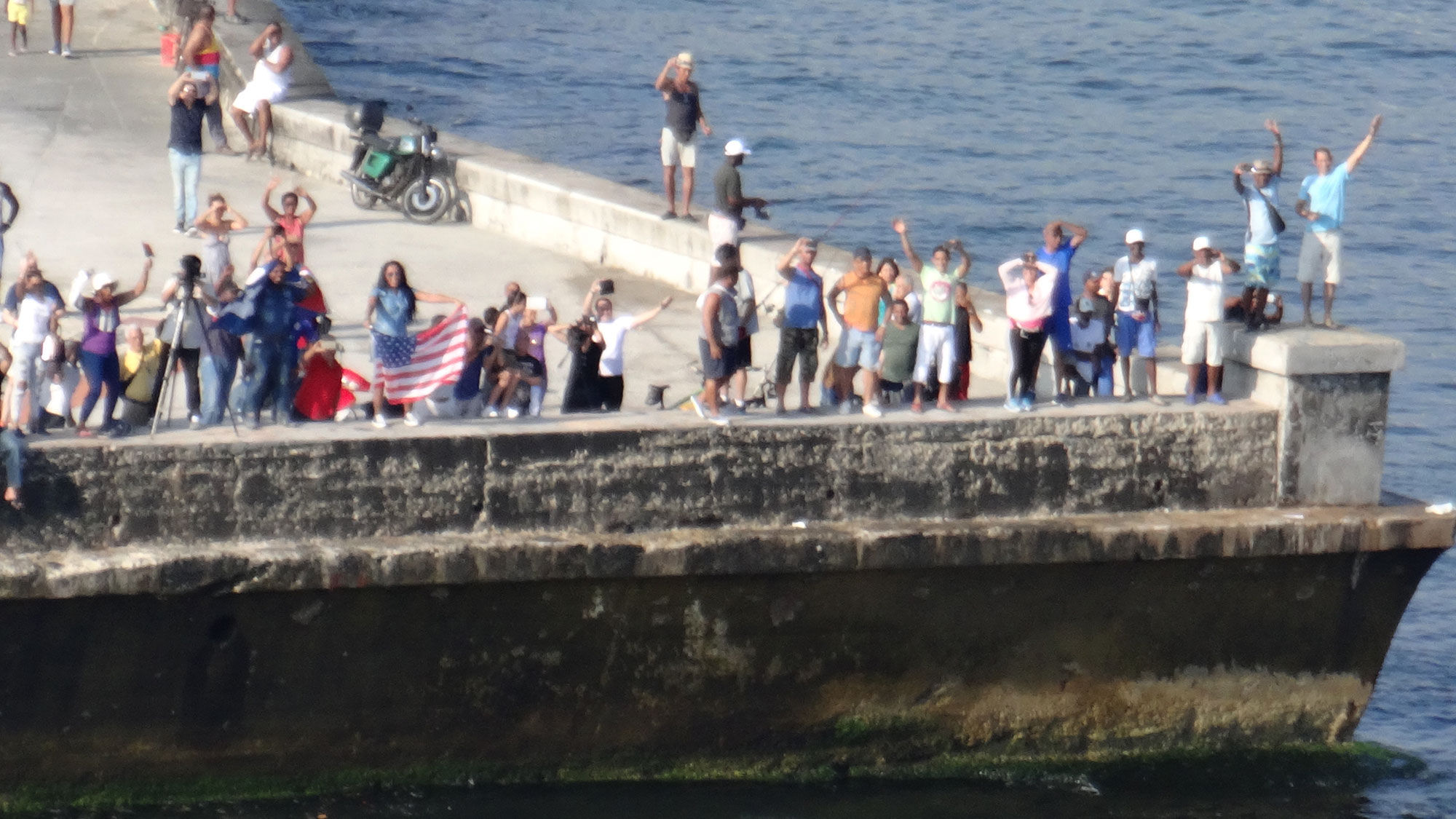 Locals line the Malecon as the Adonia approaches Havana Harbor.