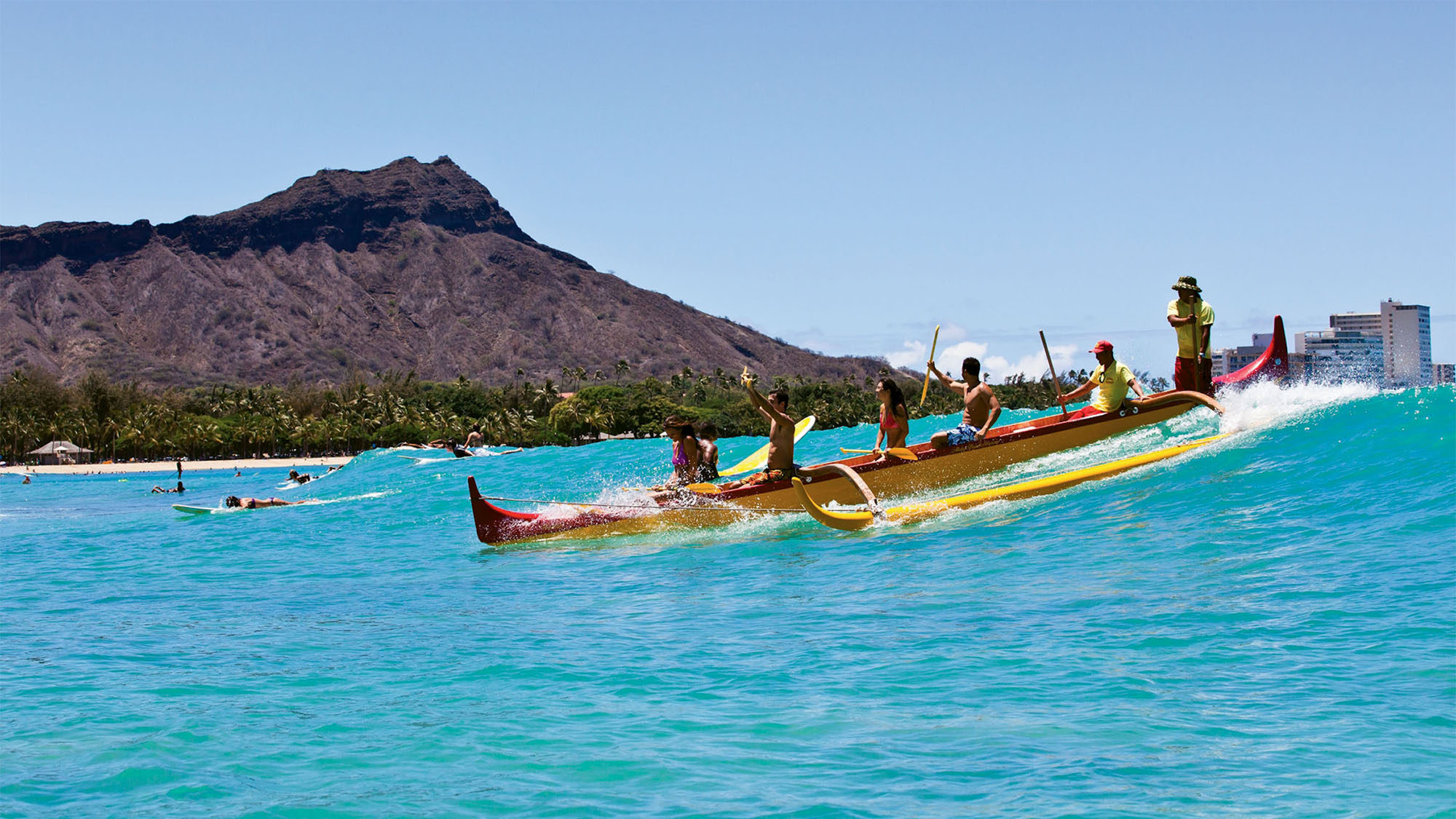 Surfers and an outrigger canoers share the waves off Waikiki. The range of activities on Oahu is beginning to widen.