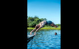 A passenger on the Kayama VIP dives into the clear waters of an offshoot of the Paraguay River.