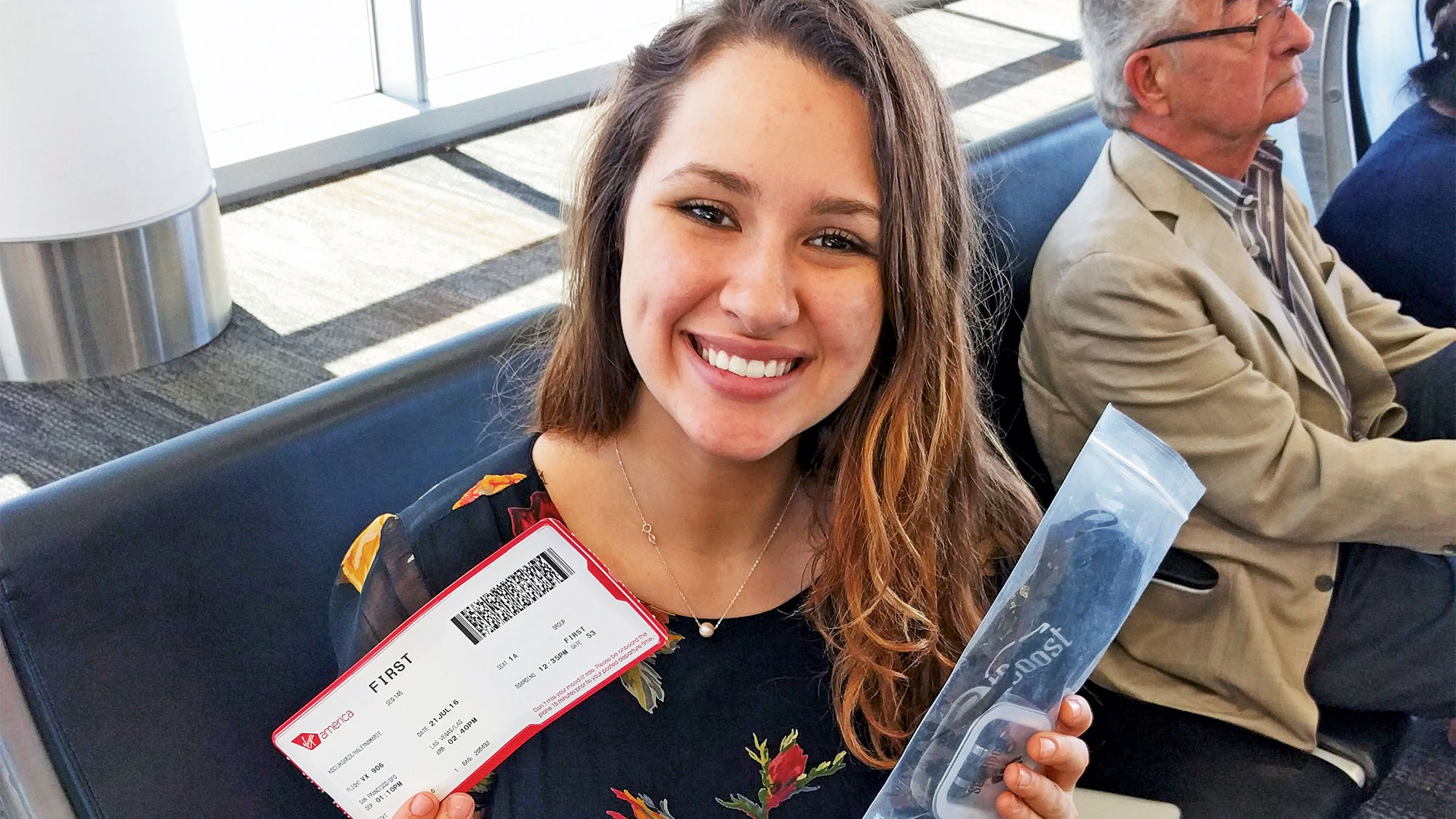 A winner of a SeatBoost Virgin America auction shows off her first-class ticket.