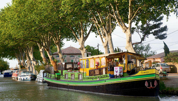 Tomata is a green barge docked near the town’s arched stone bridge where sailors can stock up on provisions as they continue down the Midi toward the ending point in Trebes. Tomata is a green barge docked near the town’s arched stone bridge where sailors can stock up on provisions as they continue down the Midi toward the ending point in Trebes.