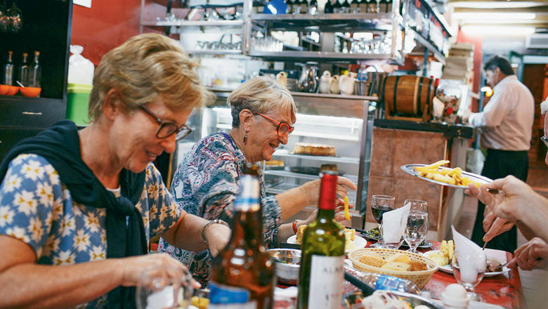 Leora Benjamin, left, and Isobel Lamont feast at a traditional restaurant in the San Telmo neighborhood of Buenos Aires with Peregrine Adventures.