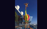 One level above the pool deck, Royal Caribbean International's Anthem of the Seas features an outdoor sculpture of a giraffe wearing an inner tube.