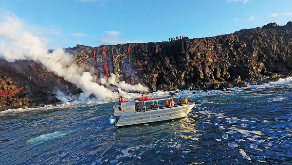 Lava Ocean Tours boat and hikers (on cliff) view Kilauea’s lava flow as it enters the ocean. Lava Ocean Tours boat and hikers (on cliff) view Kilauea’s lava flow as it enters the ocean.