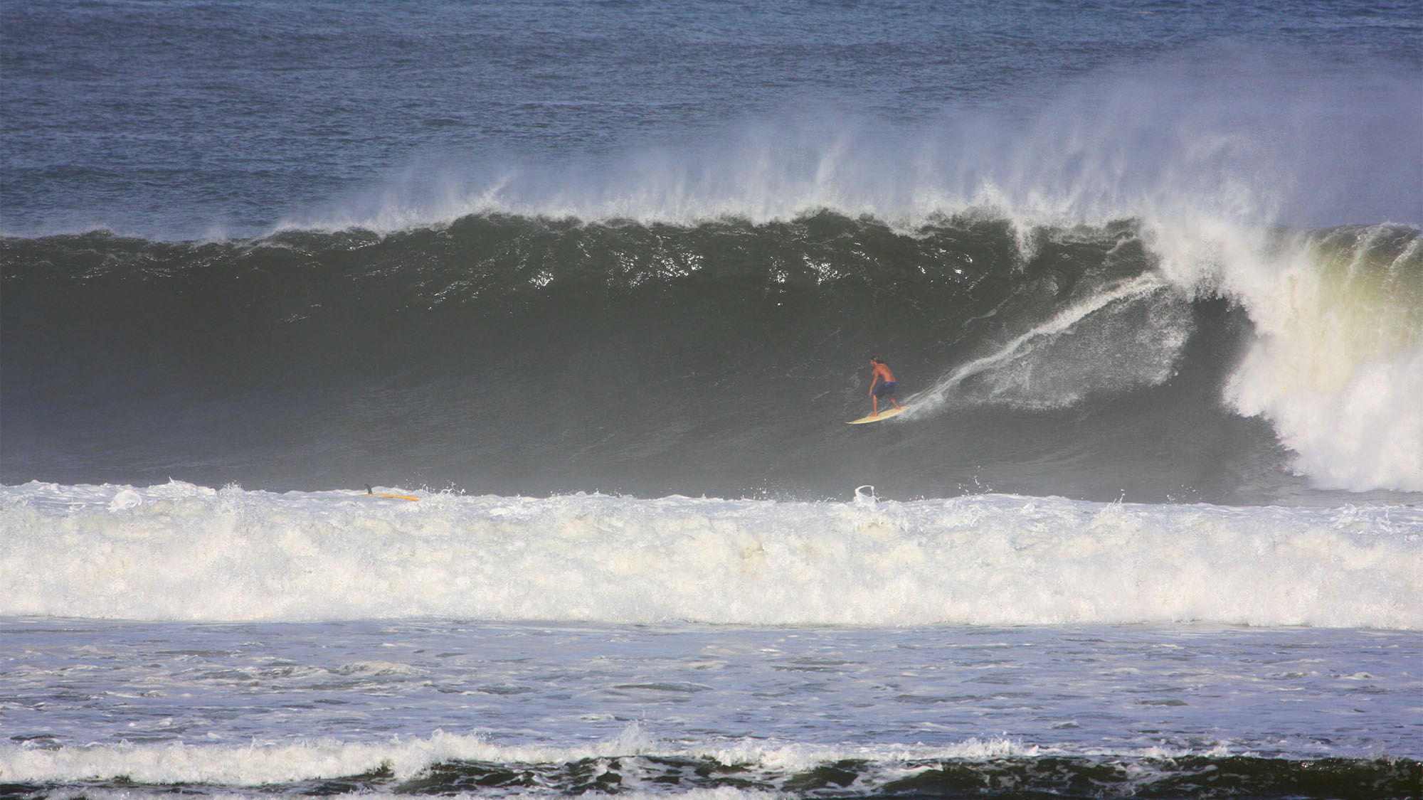 Mitchell Alapa, the son of the owners of Hawaiian Surfing Adventures, rides a triple-overhead wave at Hanalei Bay.