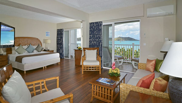 A one-bedroom, oceanview room at the Grand Case Beach Club, which features one king-size bed in the bedroom with one pullout sofa in the living room.