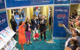 Celebrity Cruises' Dondra Ritzenthaler toasts the CruiseWorld crowd before cutting the ribbon to officially open the CruiseWorld exhibitor showcase.