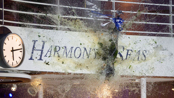 A 3-foot bottle of champagne smashes into the Harmony of the Seas.