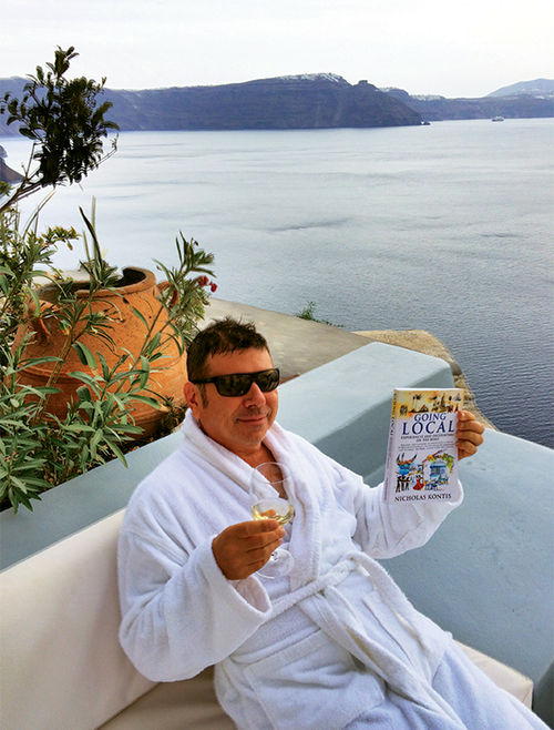 Nick Kontis in Santorini with his book, “Going Local: Experiences and Encounters on the Road,” inspired by his travel experiences. Nick Kontis in Santorini with his book, “Going Local: Experiences and Encounters on the Road,” inspired by his travel experiences.