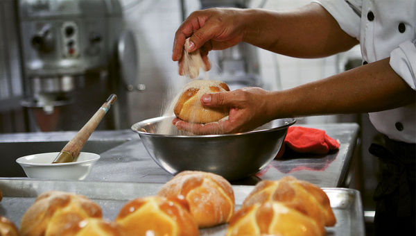 Pastry chef Mauricio Romero sprinkles cinnamon and sugar on pan de muerto at the CasaMagna Marriott Puerto Vallarta Resort & Spa. Pastry chef Mauricio Romero sprinkles cinnamon and sugar on pan de muerto at the CasaMagna Marriott Puerto Vallarta Resort & Spa.