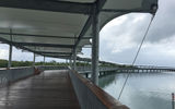 A canopy provides shade and rain cover on the long pier that connects the dock to the entrance of Harvest Caye.