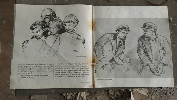 A schoolbook featuring images of Soviet revolutionary Vladimir Lenin, on the floor of the town’s abandoned school.
