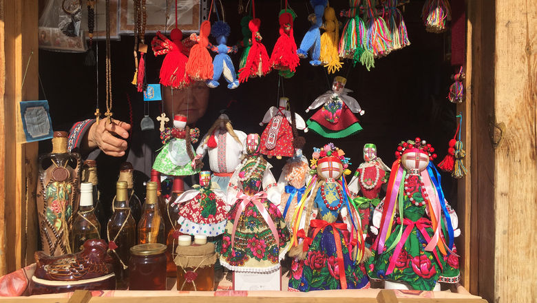 A woman selling traditional dolls and homemade spirits at Kievan Rus Park.