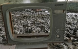 Gas masks that were being stored in a Pripyat school lay strewn over the floor of the cafeteria, partially framed by a tubeless television.