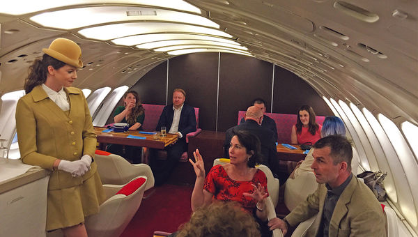 Passengers chat with a stewardess in the upstairs lounge. Passengers chat with a stewardess in the upstairs lounge.