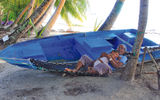 A baby rests on his grandfather in a hammock on Fiyoaree.