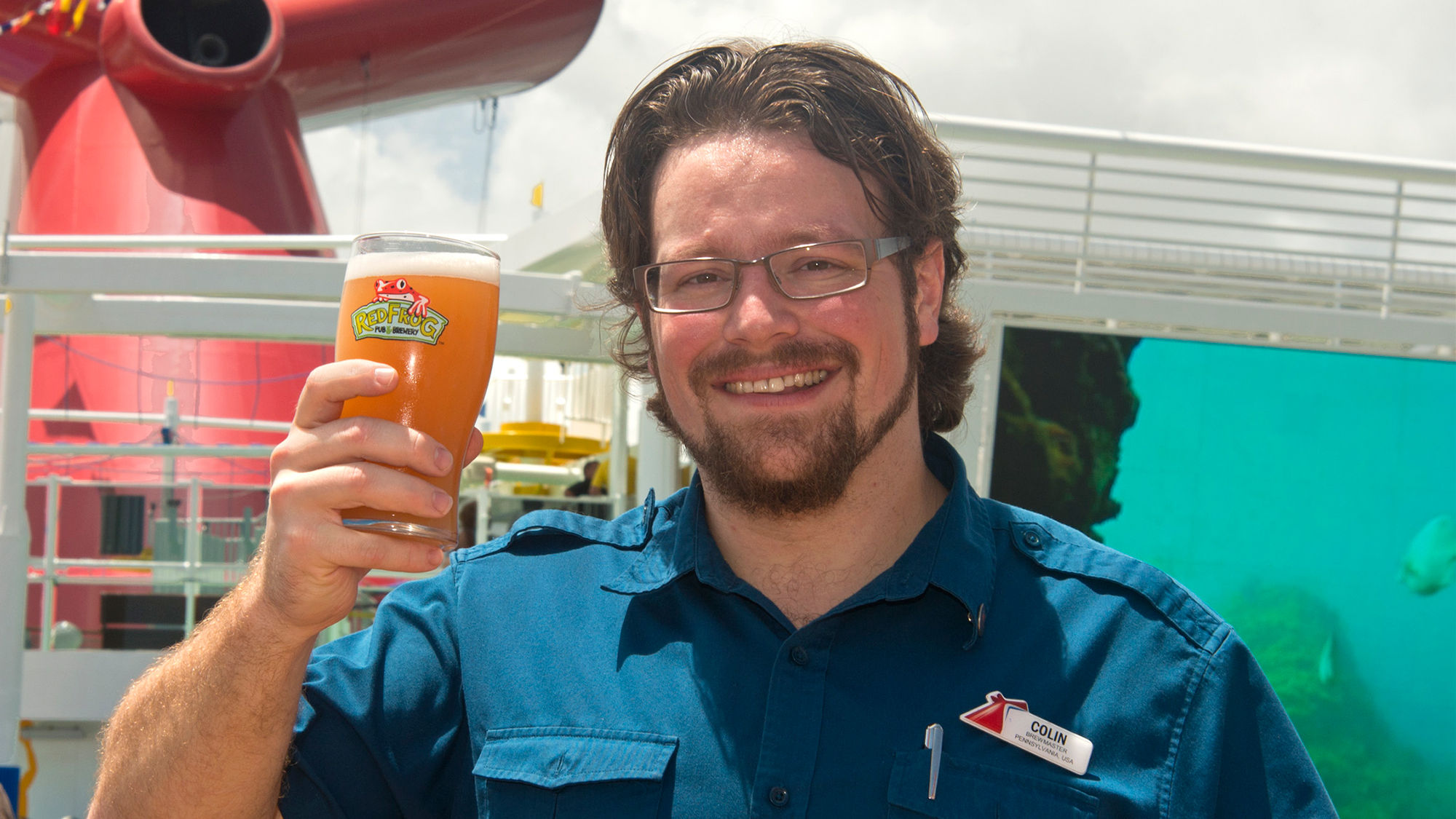 Carnival Vista brewmaster Colin Presby with a glass of Miami Guava Wheat.