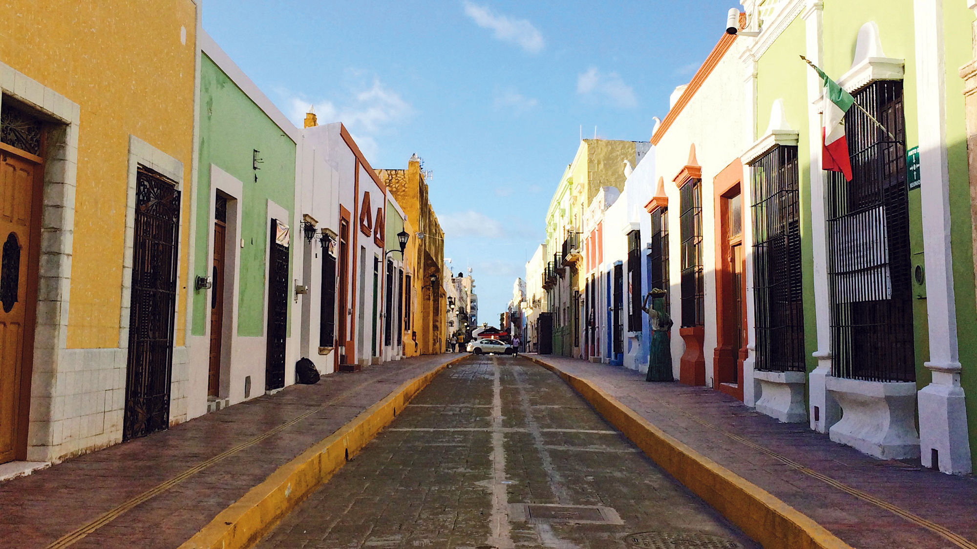 The historical center of Campeche City has cobblestone streets flanked by colorful buildings.