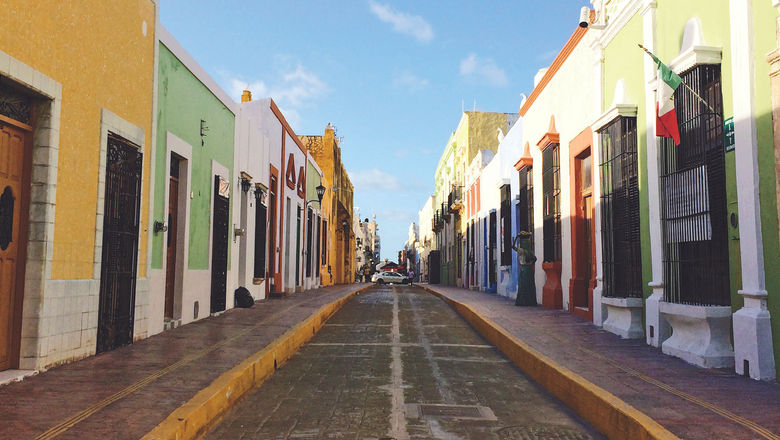 The historical center of Campeche City has cobblestone streets flanked by colorful buildings.