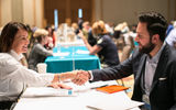 Travel advisor Ginny Mariano, Avanti, and Omar Banihani, Jordan Tourism Board, shake hands after a successful 6-minute meeting.
