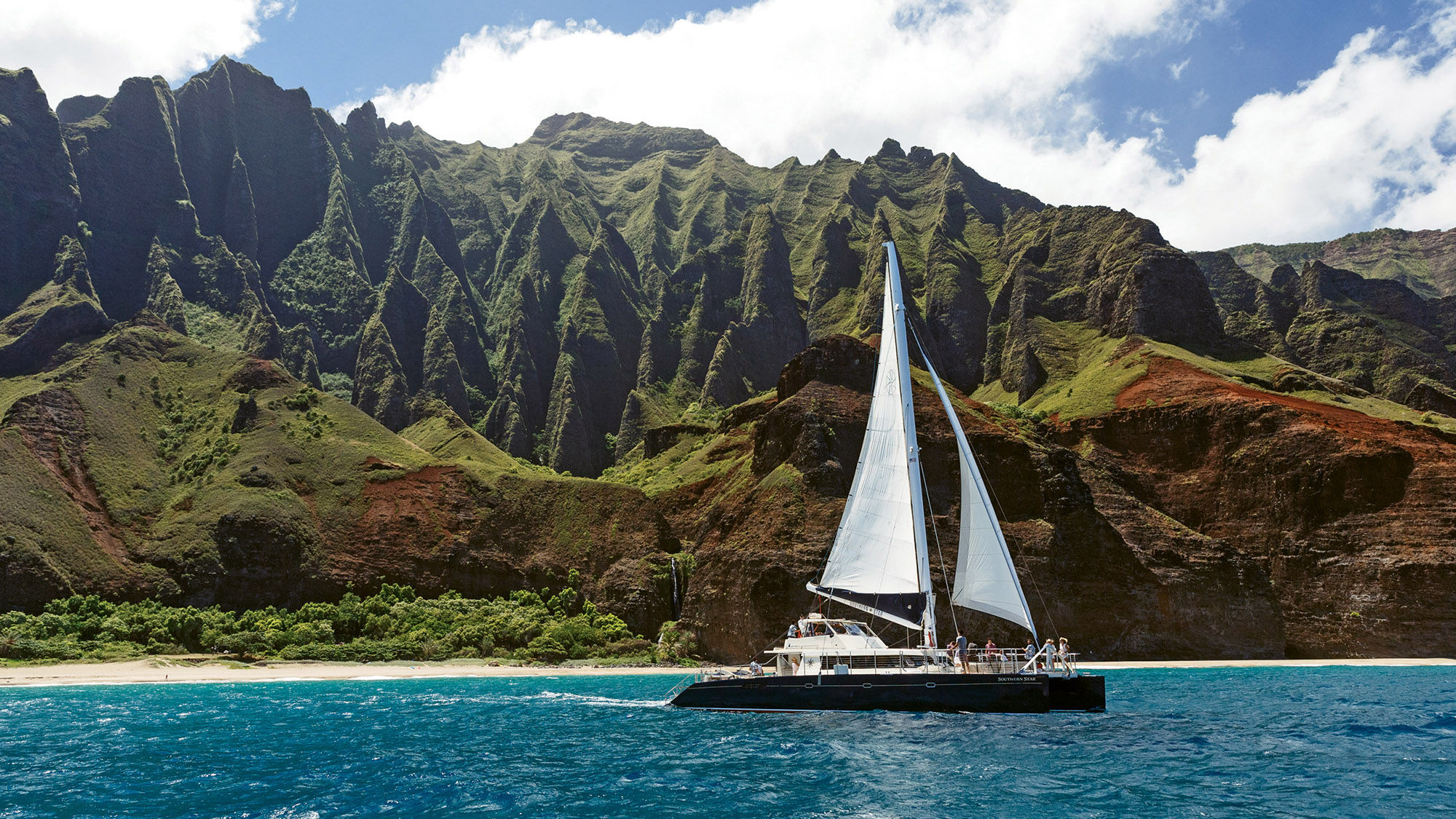 A Capt. Andy’s catamaran sailing along the Napali Coast. The Kauai company’s tours include the Star Napali Snorkel BBQ Sail.