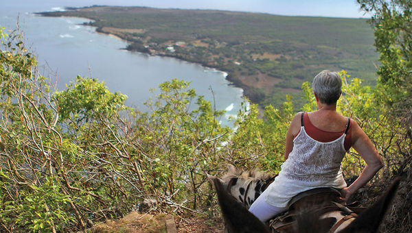 A visitor takes in the view of Kalaupapa below as she makes her way down the steep trail on a mule. A visitor takes in the view of Kalaupapa below as she makes her way down the steep trail on a mule.